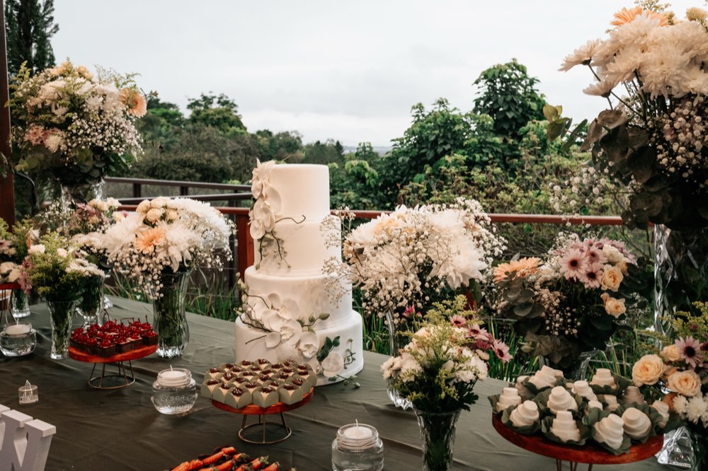 Mesa do bolo decorada com flores ao ar livre