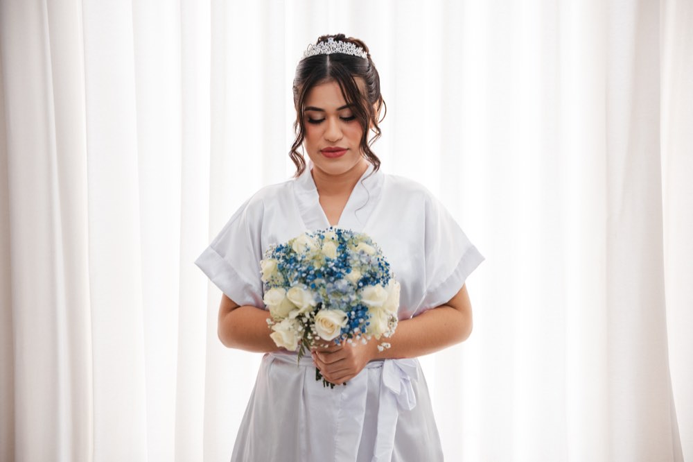Noiva de robe branco segurando o buquê antes da cerimônia